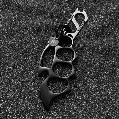 Black keychain EDC knuckle accessory on textured background